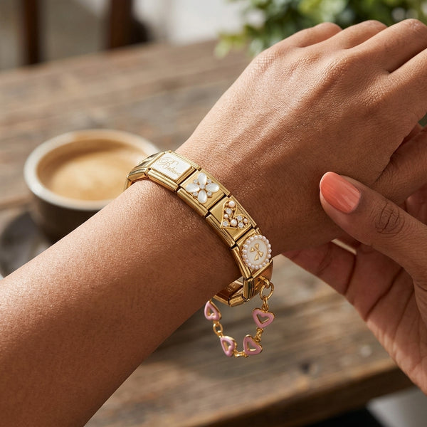 Gold 9mm Italian charm bracelet with pink enamel heart accent chain on a wrist.