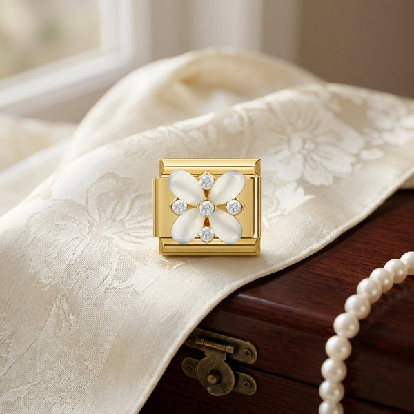 Gold 9mm Italian charm with floral design and crystals on a textured fabric surface with pearls
