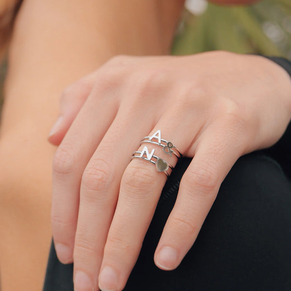 Womans Hand With Silver Initial Rings Letters A & N With A Silver Heart