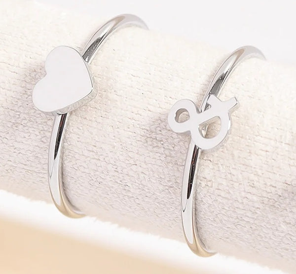 Silver Rings On Display Showing Heart And Ampersand