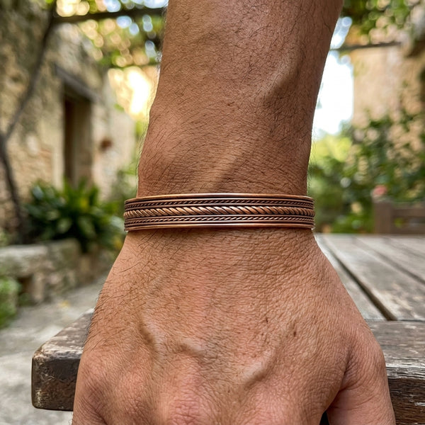 Rope Channel Copper Cuff Bracelet on male models wrist, outdoor background