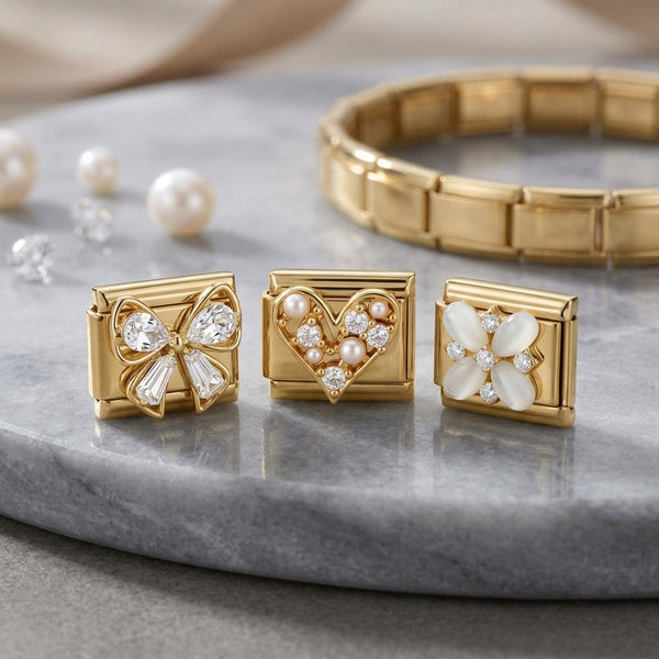 Gold 9mm Italian charm trio on marble counter with pearls and diamonds in the background with gold charm bracelet