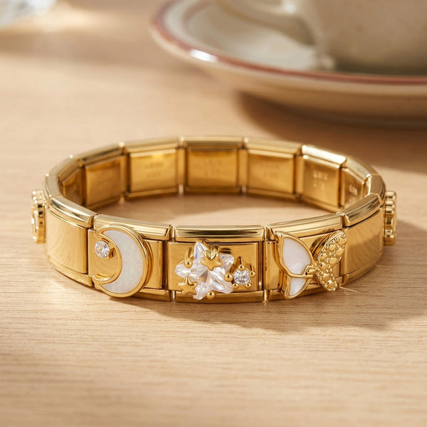 Gold 9mm Italian charm bracelet with butterfly, moon and crystal star designs on a wooden surface