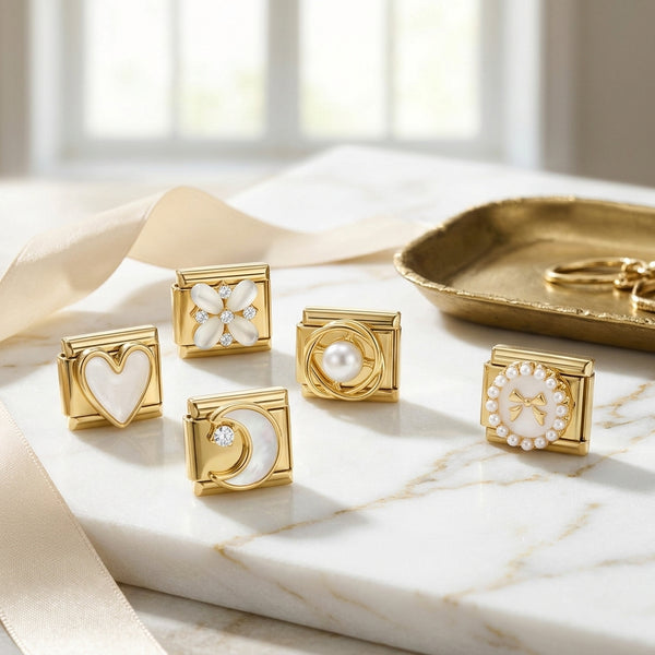 Gold 9mm Italian charms with heart, moon, and pearl designs on a marble surface.