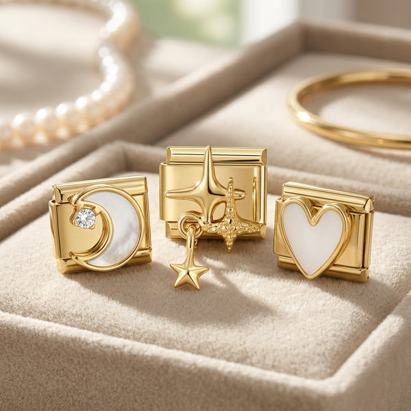 Gold 9mm Italian charms with heart, star, and moon designs on a beige surface.